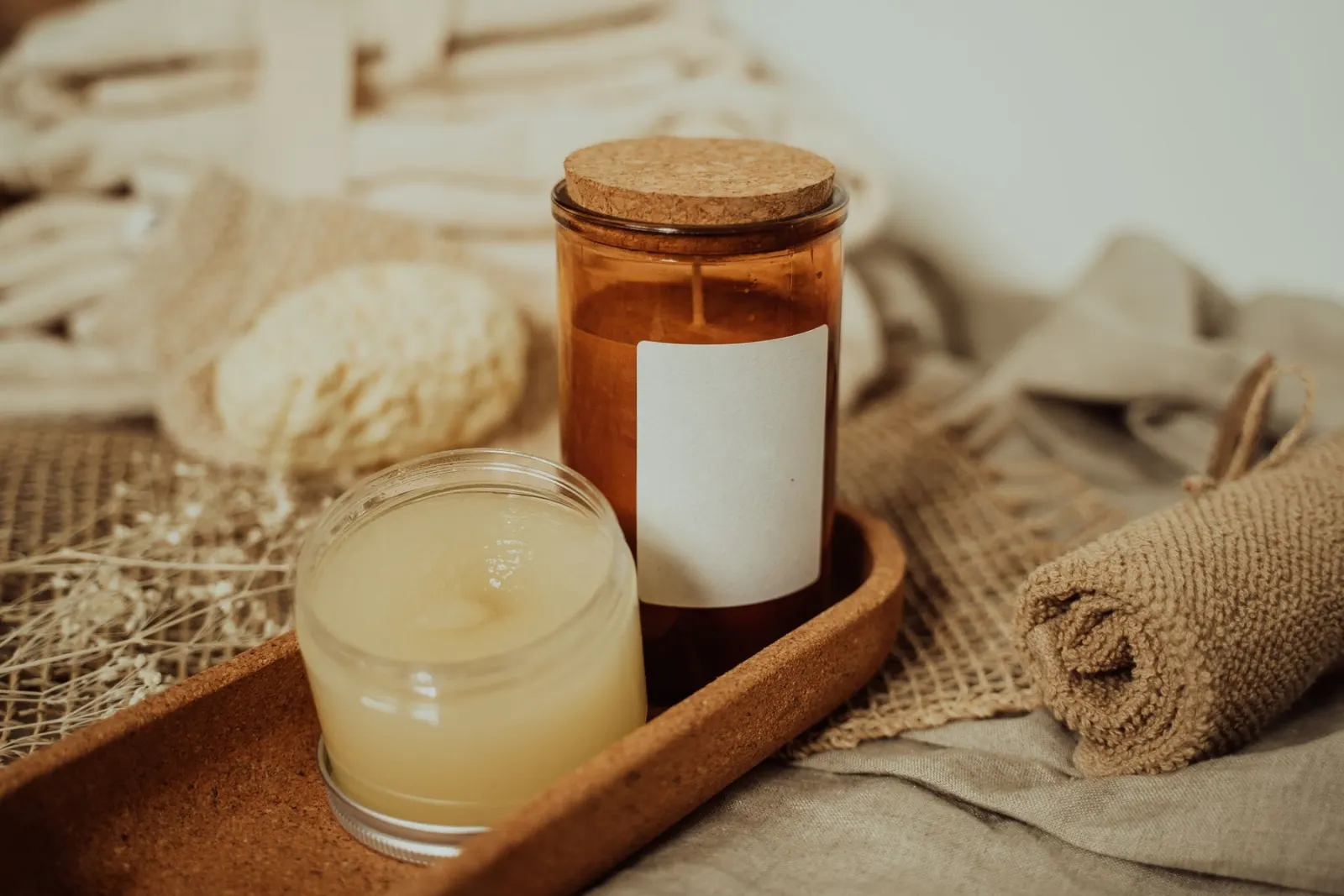 Candle, towel and natural spa products on a wooden tray